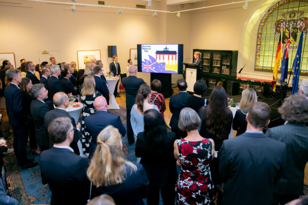 Eine Veranstaltung mit Rednerin und stehenden Zuhörern